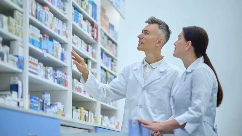 Personal de farmacia revisando fecha de caducidad en cajas de medicamentos