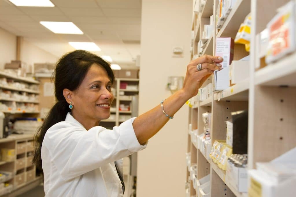 Farmacéutica seleccionando un medicamento del inventario de una farmacia hospitalaria