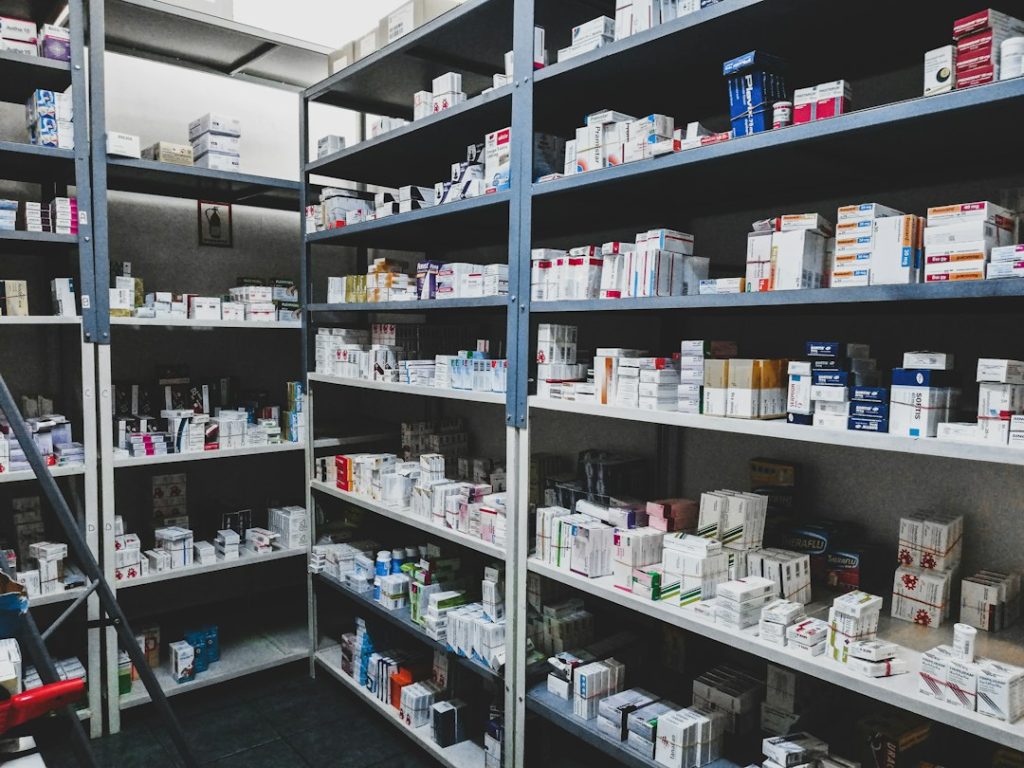 Anaqueles de almacén farmacéutico con cajas de medicamentos ordenadas por lote