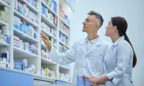 Personal de farmacia revisando fecha de caducidad en cajas de medicamentos