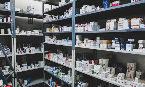 Anaqueles de almacén farmacéutico con cajas de medicamentos ordenadas por lote